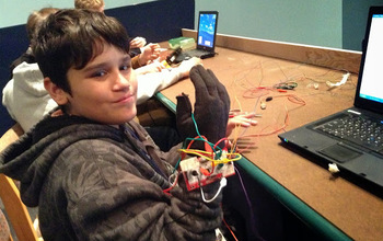 child with laptop and wires on a hand